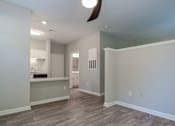 Thumbnail 17 of 35 - A room with a kitchen area and a fan on the ceiling.