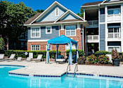 Thumbnail 28 of 35 - A blue umbrella is next to a swimming pool.