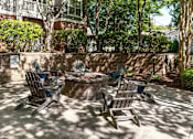 Thumbnail 27 of 35 - A fire pit surrounded by chairs in a sunny backyard.