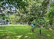 Thumbnail 22 of 24 - A playground with a slide and a swing set in a green park.