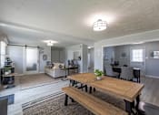 Thumbnail 4 of 24 - A modern open plan living and dining area with a wooden table and bench.