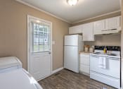 Thumbnail 9 of 24 - A kitchen with white appliances and wooden floors.