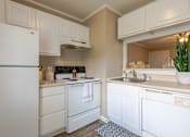 Thumbnail 8 of 24 - A white refrigerator is in a kitchen with white cabinets.