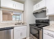 Thumbnail 18 of 24 - A kitchen with white cabinets and a stainless steel dishwasher.