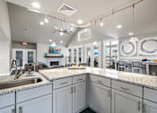 Thumbnail 12 of 42 - A kitchen with a granite countertop and a ceiling fan.