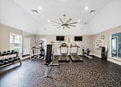 Thumbnail 19 of 42 - A spacious home gym with a variety of equipment including a treadmill, stationary bike, and weight bench.