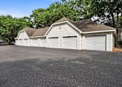 Thumbnail 42 of 42 - A two-car garage with a brown roof is surrounded by trees.
