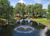 Thumbnail 37 of 42 - A fountain in the middle of a pond surrounded by trees.