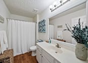 Thumbnail 9 of 42 - A bathroom with a white toilet, a white sink, and a white shower curtain.