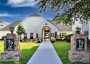 Thumbnail 2 of 42 - A white building with a stone pillar in front of it.
