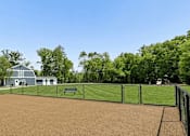 Thumbnail 11 of 19 - A baseball field with a fence and a bench.