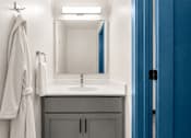 Thumbnail 7 of 7 - A bathroom with a white sink and a white towel hanging on the wall.