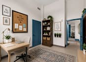 Thumbnail 4 of 7 - A room with a cork board on the wall that says "You belong here" and a desk with a laptop and a plant.