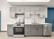 Thumbnail 5 of 7 - A modern kitchen with a stainless steel oven and sink.