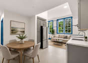 Thumbnail 2 of 7 - A modern kitchen with a dining table and chairs.