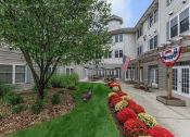 Thumbnail 5 of 57 - a courtyard with a tree and flowers in front of an apartment building
