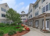 Thumbnail 7 of 57 - an apartment building with a walkway and a flag in the courtyard