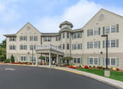 Thumbnail 8 of 57 - a large building with a porch and a street in front of it