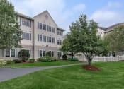 Thumbnail 9 of 57 - an apartment building with a yard and trees in front of it