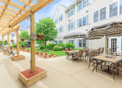 Thumbnail 15 of 57 - a patio with tables and umbrellas in front of a building