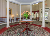 Thumbnail 24 of 57 - a view of the lobby of a building with columns and a table with a v