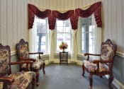 Thumbnail 28 of 57 - a living room with chairs and windows with curtains
