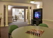 Thumbnail 31 of 57 - a living room with a chess board and a tv