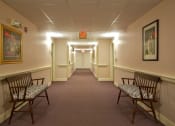 Thumbnail 33 of 57 - a long corridor with chairs in a hall way