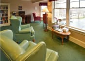Thumbnail 36 of 57 - a living room with green chairs and a table