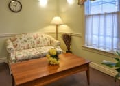 Thumbnail 38 of 57 - a living room with a couch and a table with flowers