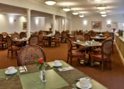 Thumbnail 42 of 57 - a dining room with tables and chairs and a vase of flowers