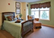 Thumbnail 43 of 57 - a bedroom with a bed and a chair and a window