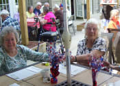Thumbnail 47 of 57 - two elderly women sitting at a table with flowers