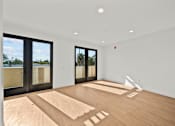 Thumbnail 10 of 11 - A room with wooden floors and white walls.