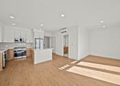 Thumbnail 1 of 11 - A kitchen with white cabinets and a wooden floor.