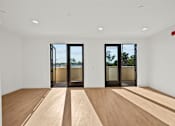Thumbnail 2 of 11 - A room with wooden floors and two sliding glass doors.