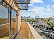 Thumbnail 4 of 11 - A balcony with a view of a street and cars.