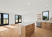 Thumbnail 8 of 11 - A kitchen with wooden floors and white countertops.