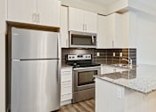 Thumbnail 10 of 44 - a kitchen with stainless steel appliances and a granite counter top