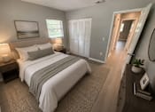 Thumbnail 4 of 11 - A bedroom with a large bed and a painting on the wall.