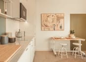 Thumbnail 4 of 36 - a kitchen and dining area with a table and chairs and a sink at Scout Living, powered by Placemakr Apartments, Atlanta, 30308