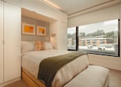 Thumbnail 25 of 36 - a bedroom with a bed and a large window at Scout Living, powered by Placemakr Apartments, Atlanta, Georgia
