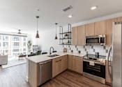 Thumbnail 18 of 23 - A modern kitchen with wooden cabinets and stainless steel appliances at Anthem House Apartment , Alabama, 35806