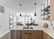 Thumbnail 23 of 23 - A modern kitchen with a stainless steel dishwasher and wooden cabinets at Anthem House Apartment , Alabama, 35806