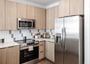 Thumbnail 16 of 23 - A kitchen with a stove, oven, refrigerator, and microwave at Anthem House Apartment , Huntsville