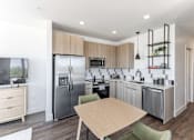 Thumbnail 11 of 23 - A modern kitchen with a wooden table and chairs at Anthem House Apartment , Alabama