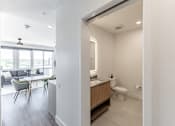 Thumbnail 13 of 23 - A bathroom with a toilet, sink, and a window at Anthem House Apartment, Huntsville, AL, 35806