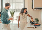Thumbnail 21 of 36 - a man and woman cooking food in a kitchen at Scout Living, powered by Placemakr Apartments, Atlanta, Georgia