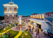 Thumbnail 33 of 36 - a crowd of people walking around an amusement park at night at Scout Living, powered by Placemakr Apartments, Atlanta