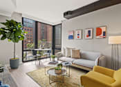 Thumbnail 25 of 28 - A living room with a yellow chair and a grey couch at Coda on Half Apartments, Washington District of Columbia
